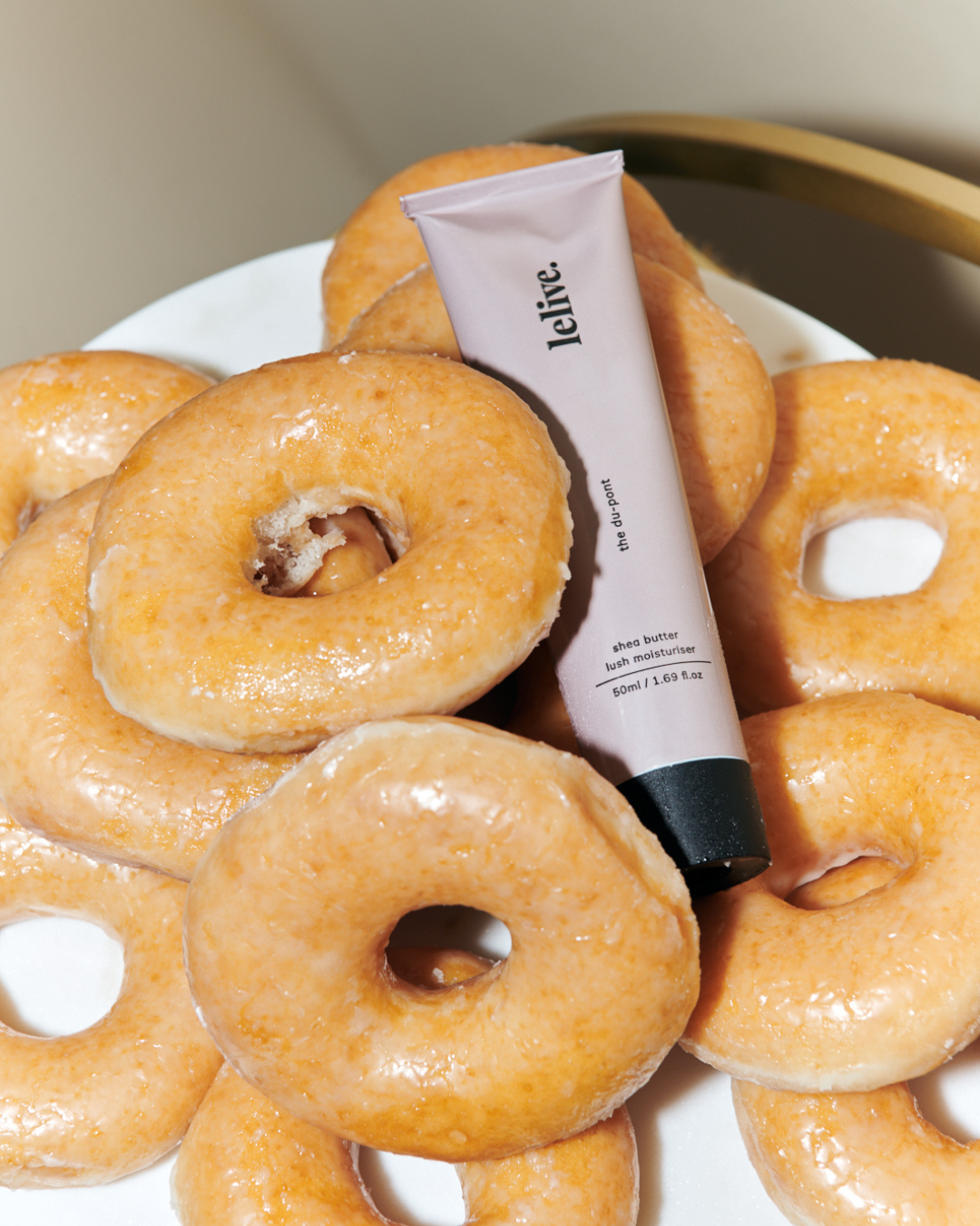 tube of moisturiser on a pile of glazed donuts, glazed donuts, glazed donut skin, donut skin, beauty, beauty trend, the suite, the suite edit, brutal fruit